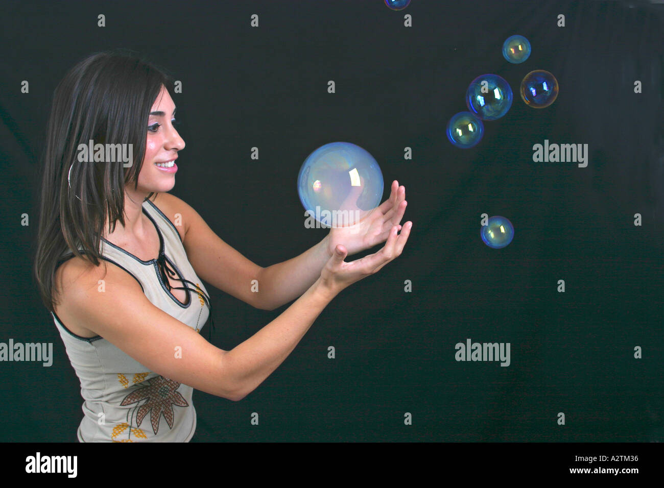 Medium-Schuss von junge Frau spielt mit Seifenblasen verrauchten Stockfoto
