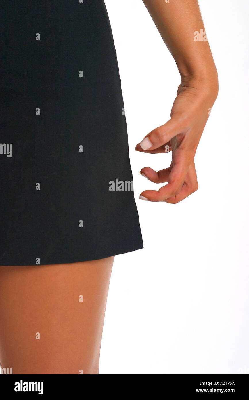 Schließen Sie Aufnahme eines gebräunte Beine und schwarzen Minirock mit krallenbewehrten Hand daneben Stockfoto