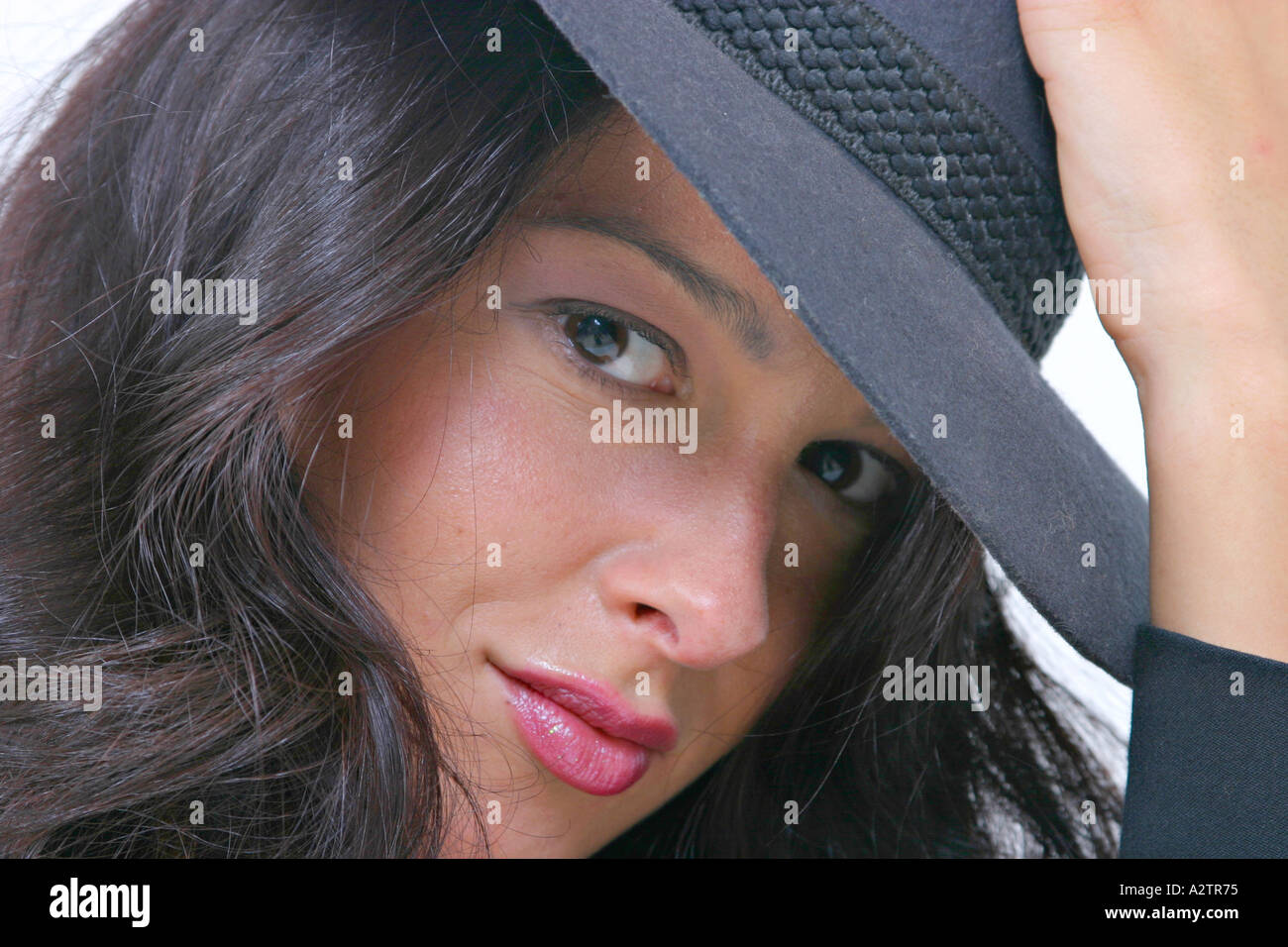 Bezugseinheiten der jungen Frau mit dunkler Filzhut mit der Hand auf den Hut in die Kamera schaut Stockfoto