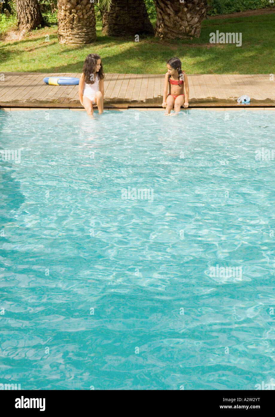 Zwei Mädchen Sitzen Am Rand Des Swimming Pool Stockfotografie Alamy 