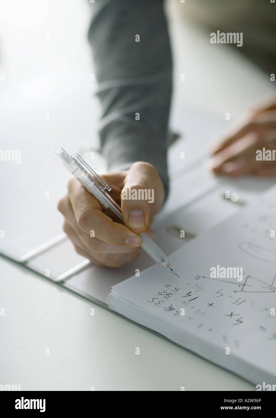 Person die Hand gestellt über Notebook mit Mathe-Noten Stockfoto