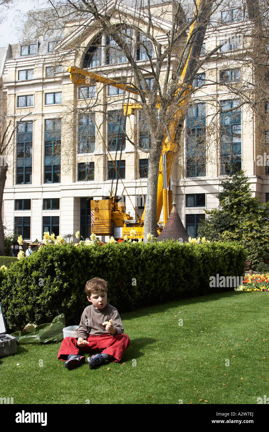 Kleiner junge Kind sitzen auf dem Rasen in Finsbury Circus City of London EC2 England NAOH Stockfoto