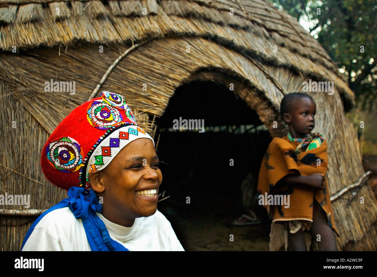 Zulu Frau im traditionellen roten Kopfschmuck einer verheirateten Frau mit Kindern Modell freigegeben Südafrika Stockfoto