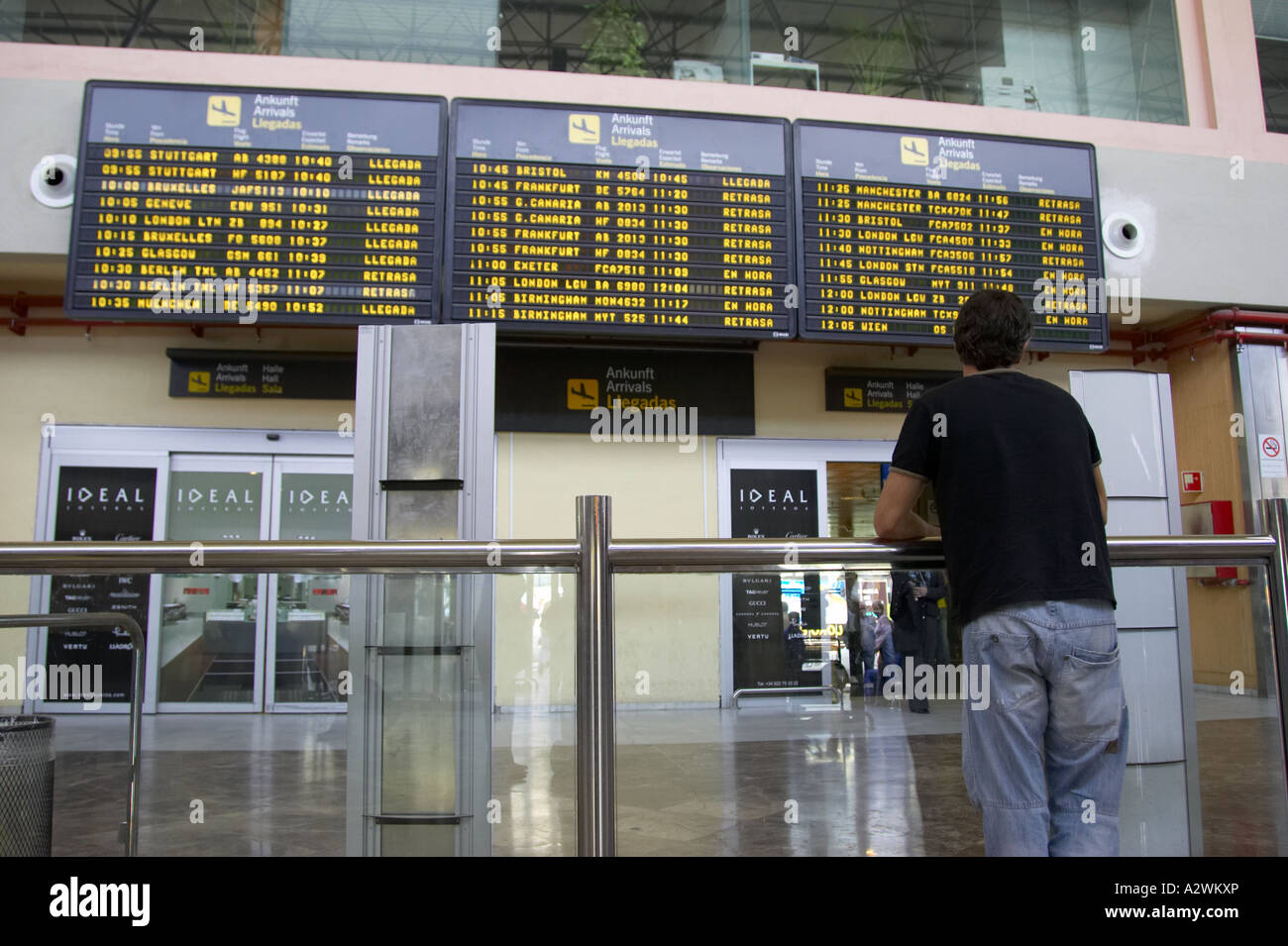 Mann wartet vor Anreise-Message-Board bei Reina Sofia Sur TFS Süd Flughafen Teneriffa Kanaren Spanien Stockfoto