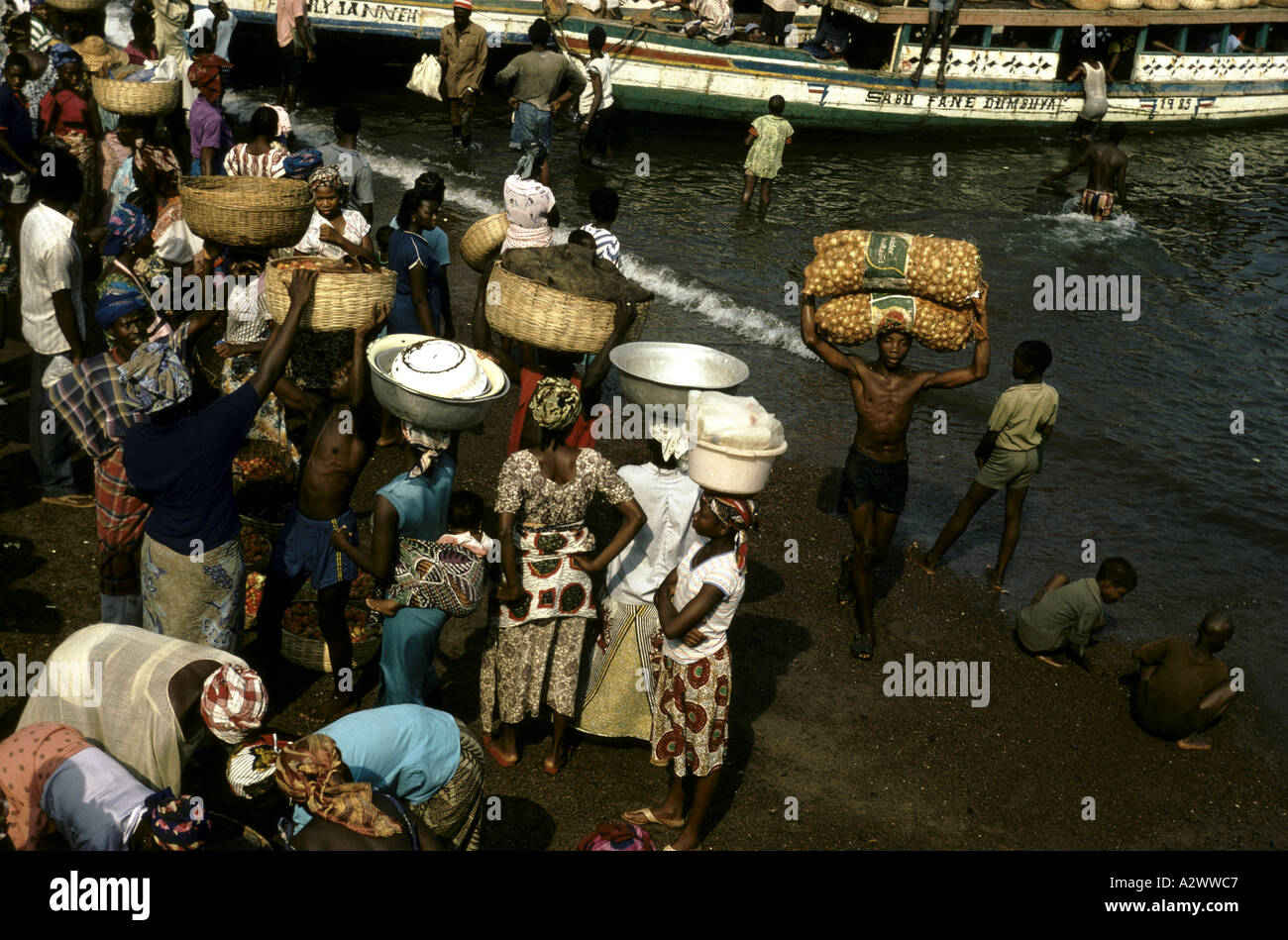 Dorfbewohner, die ihre Produkte auf ihren Köpfen tragen, für Verkauf in Freetown, Sierra Leone, Afrika Märkte Stockfoto