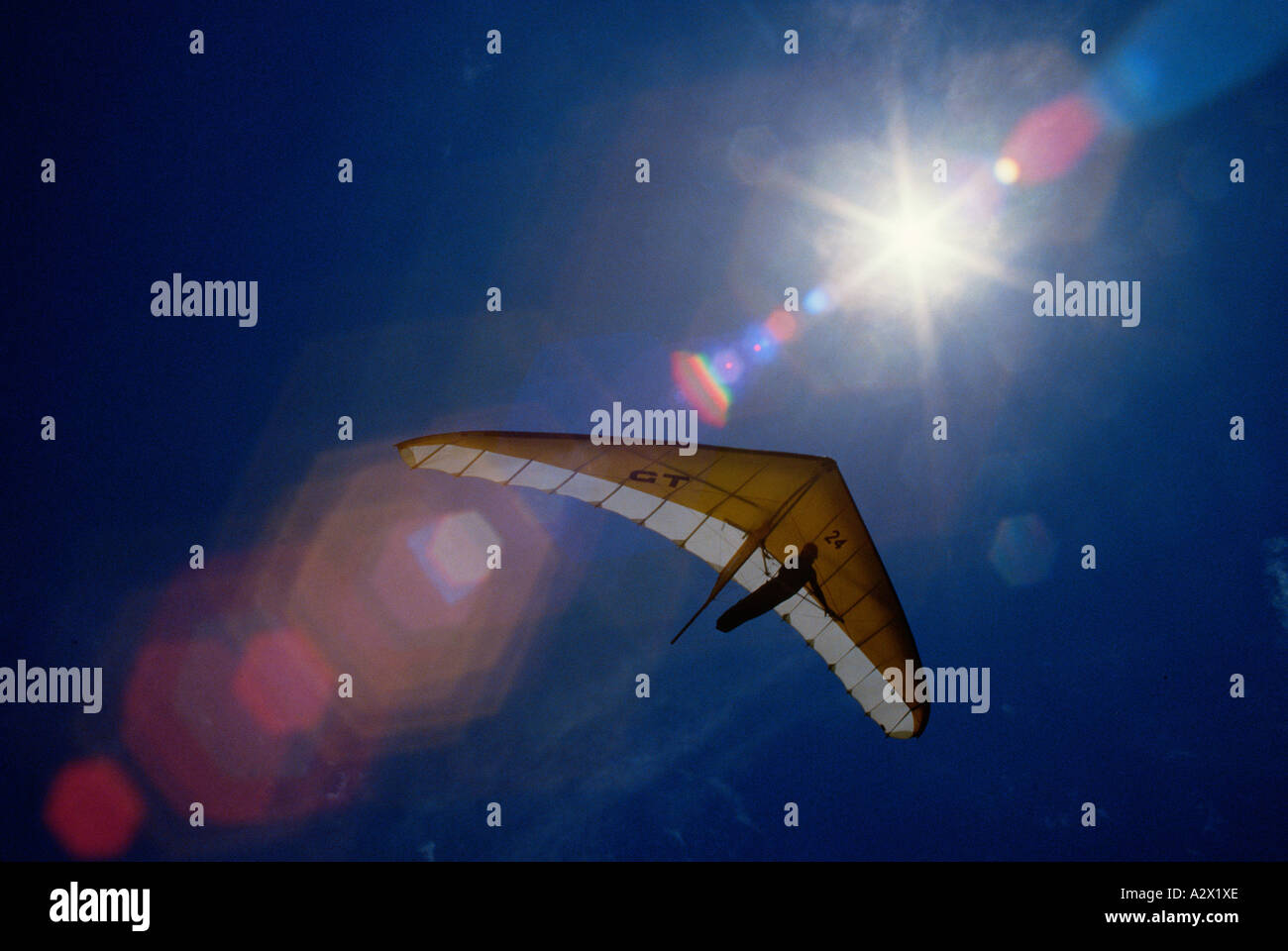Himmelwärts Ansicht der Hängegleiter im Flug gegen die Sonne mit Objektiv flare. Stockfoto