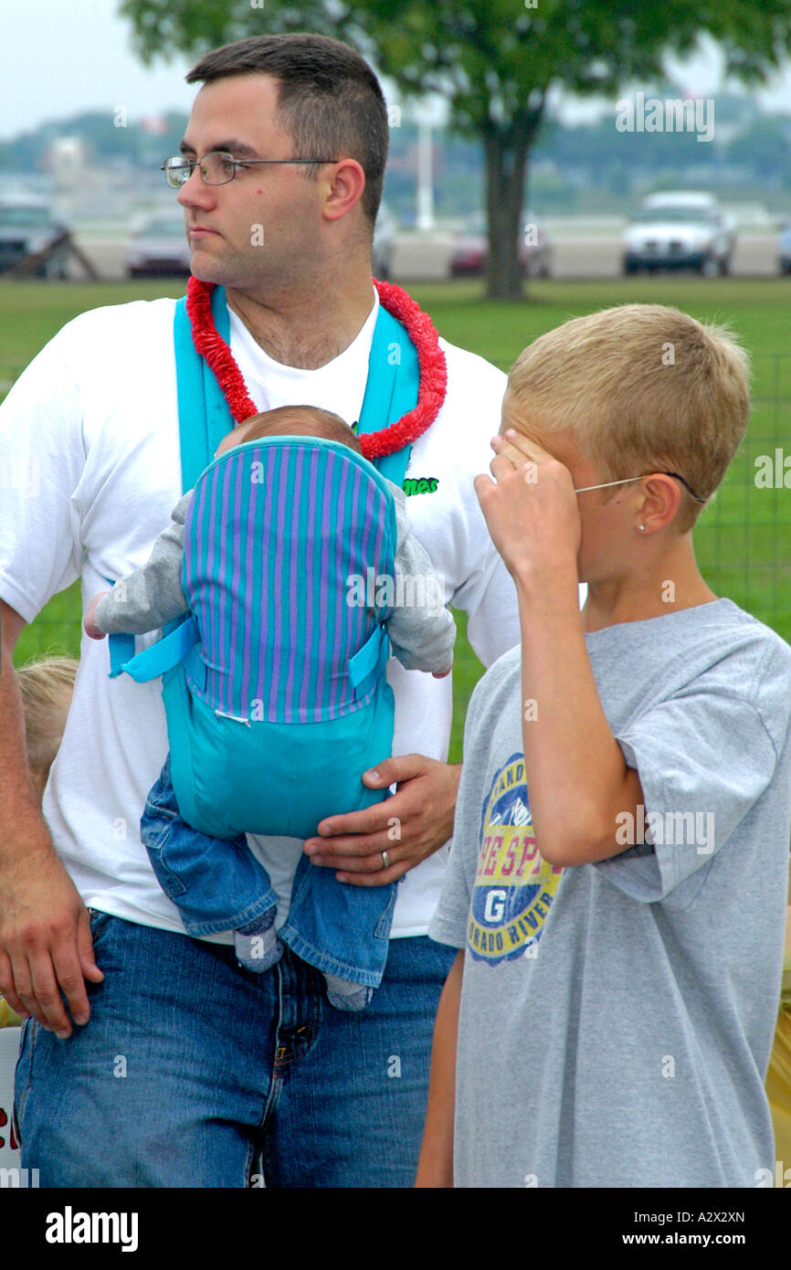 Tragen eine Wiege Kindertrage auf seiner Brust mit seinem kleinen Sohn Vater Stockfoto
