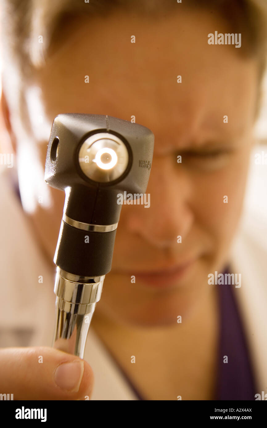 Arzt mit einer Hand gehalten Otoskop um das Trommelfell seines Patienten zu sehen. Stockfoto