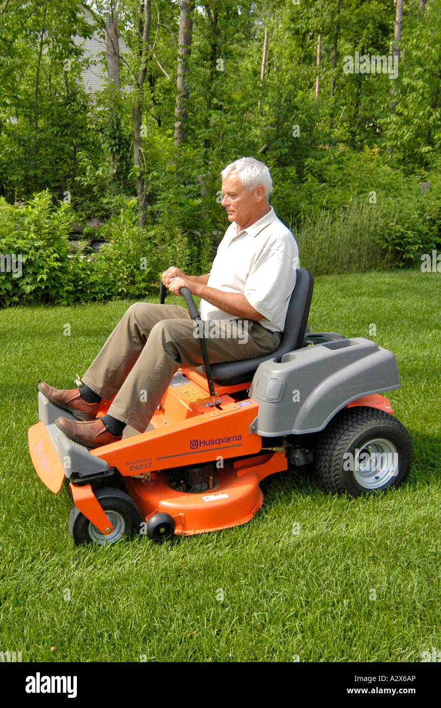 Senior männlichen Schnitt seinen Rasen mit einem Zero-Turn Aufsitzmäher Stockfoto