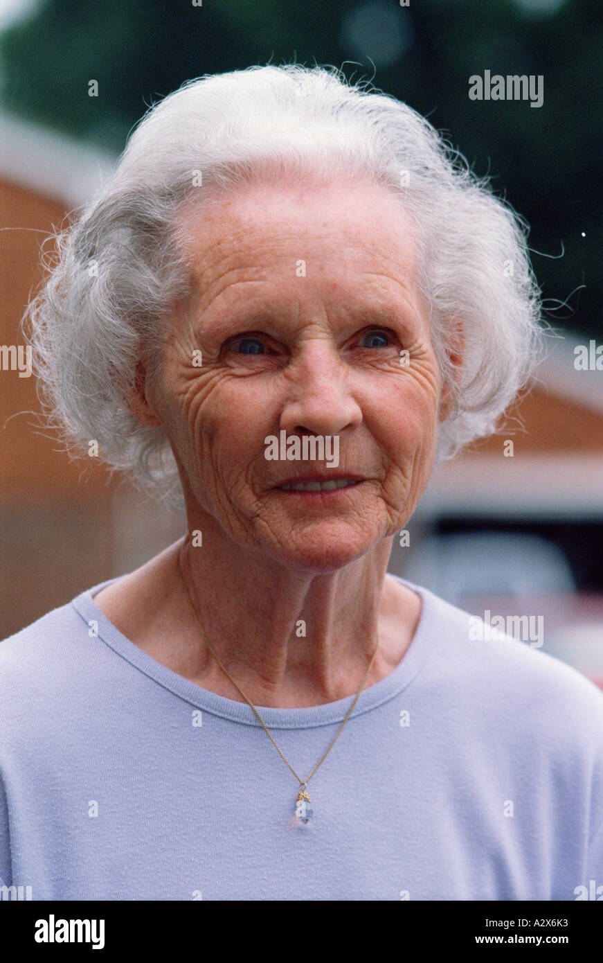 Porträt von alte Frau außerhalb Vorstadthaus. Stockfoto