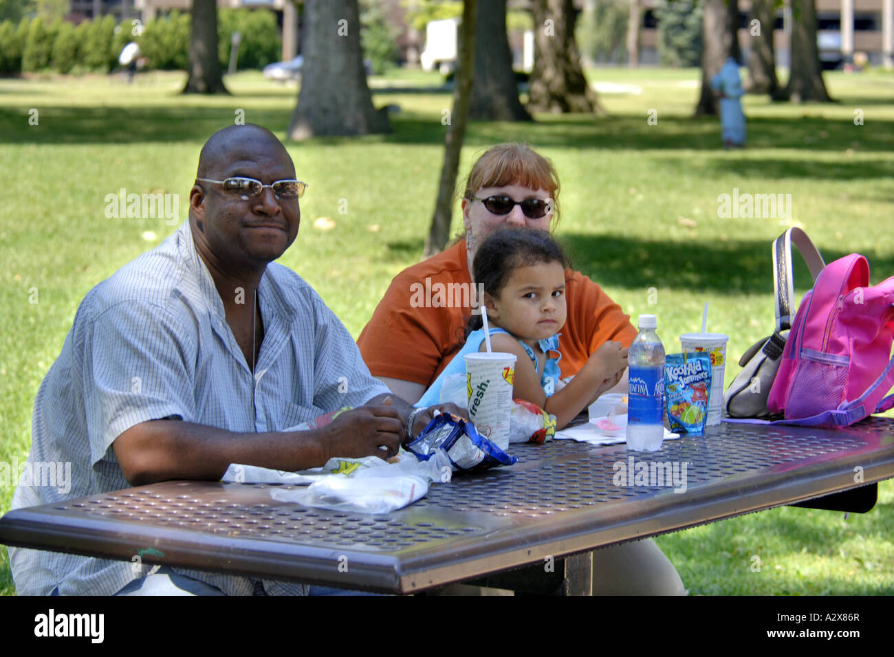 Gemischte Rassen Familie genießen ein Picknick zusammen an einem Sommertag Stockfoto