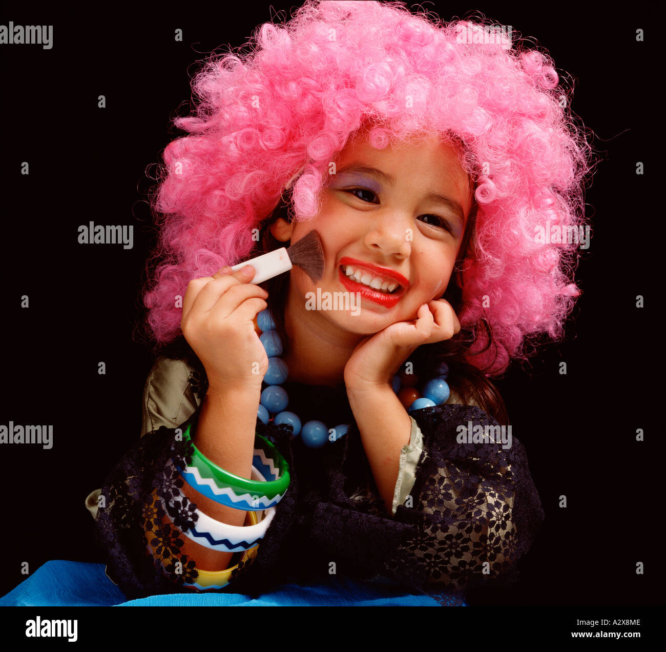 Kinder. Kleines Mädchen im Haus putzt sich das Tragen einer rosa Perücke  und Schminken Stockfotografie - Alamy