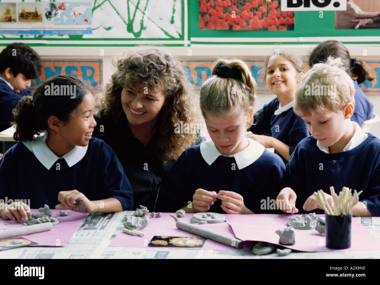 Frau Lehrerin mit Kindern. Mädchen im Klassenzimmer. Stockfoto