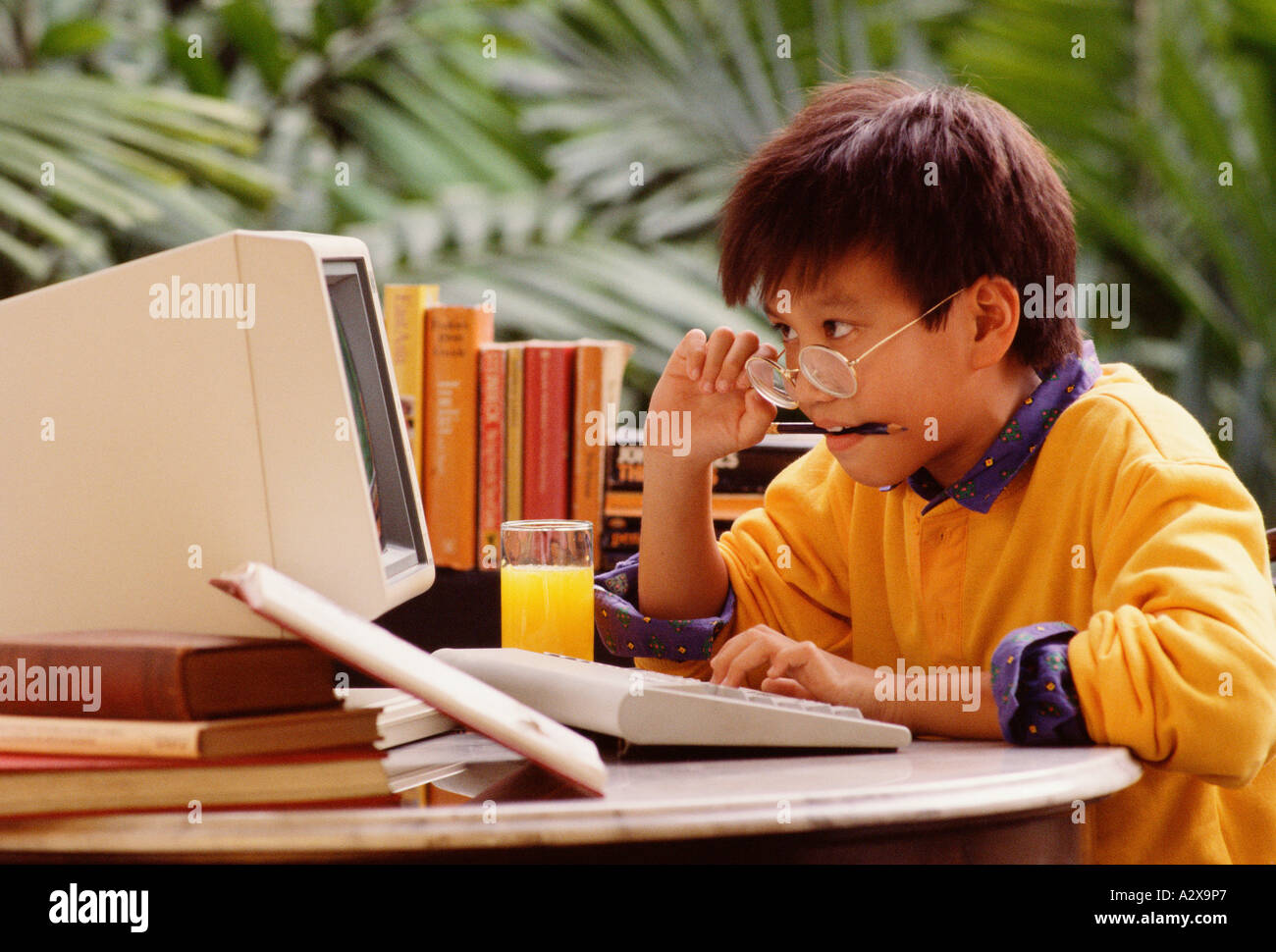Singapur. Junge Kind sitzt am Computer. Stockfoto