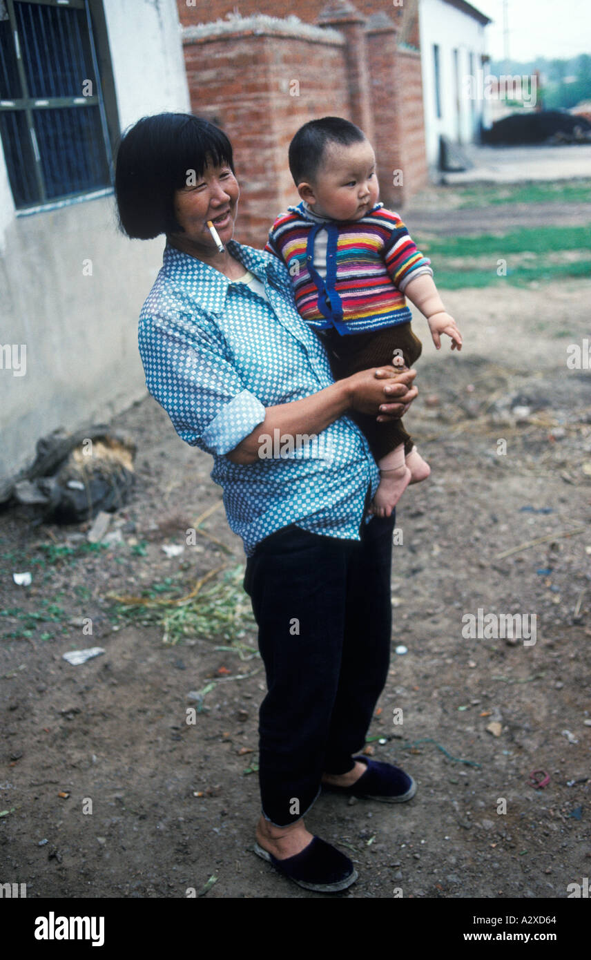 China 90er Jahre Provinz Anhui Mutter hält ein kleines Kind, das ein Zigarettendorf raucht Liufu Dorf 1998 HOMER SYKES Stockfoto