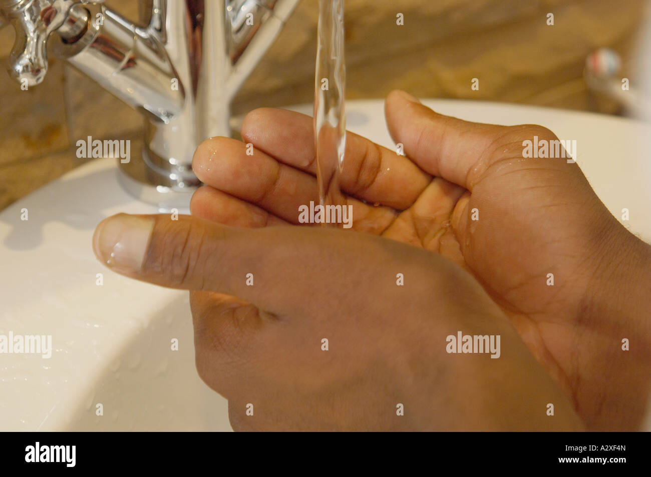 Nahaufnahme eines afrikanischen Mann s Hände unter Wasser im Waschbecken Stockfoto