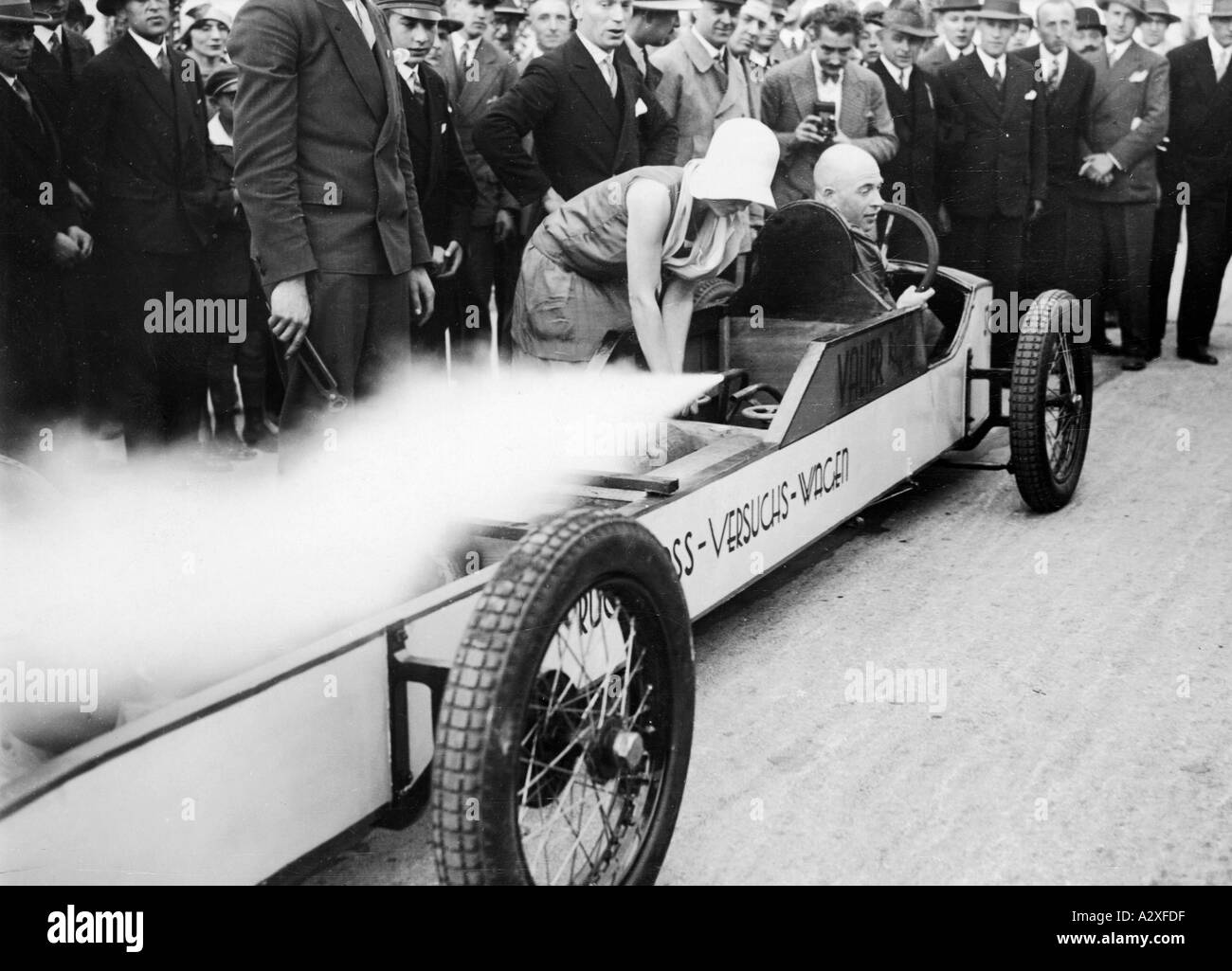 1928 baute Max Vailer zusammen mit Fritz von Opel hier den ersten deutschen Raketenwagen der Automobilgeschichte 1929 präsentierte er eine Maschine, die er im Alleingang entwickelte, ein rückstoßgetriebenes Fahrzeug mit Raketenantrieb, das funktioniert völlig geräuschlos und ohne Gefahr gemeinsam mit Fritz von Opel konstruierte Max Valier 1928 den ersten deutschen Raketenwagen der in die Automobilgeschichte eingegangen ist hier praesentiert er 1929 den im Alleingang entwickelt Rueckstosswagen dessen Antrieb durch Pulverraketen erfolgt die voellig Geraeuschlos arbeitet neugierige Momente S 172 Stockfoto
