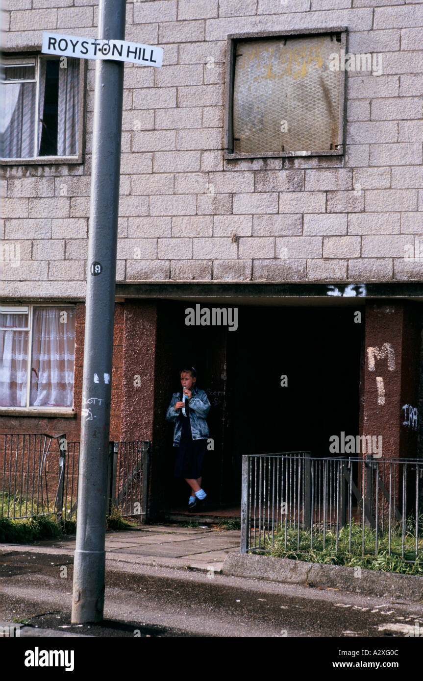 Ein Schulmädchen wartet auf einen Freund in Possil Park, einem heruntergekommenen Viertel in Glasgow Stockfoto