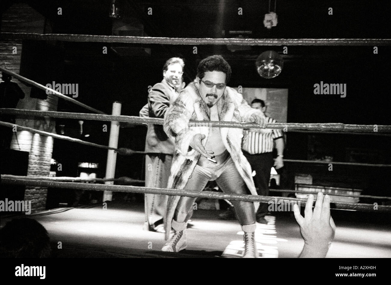 Midget Wrestler verhöhnt das Publikum und einen weiteren Teilnehmer in einem Nachtclub Mitte der 1990er Jahre Stockfoto