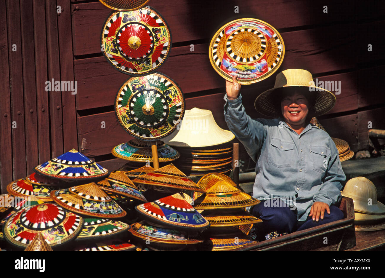 THAILAND Floating Market am Klong Damern Saduak in der Nähe von Bankok Frau verkaufen hell farbigen geflochtenen Stroh Hüte Stockfoto