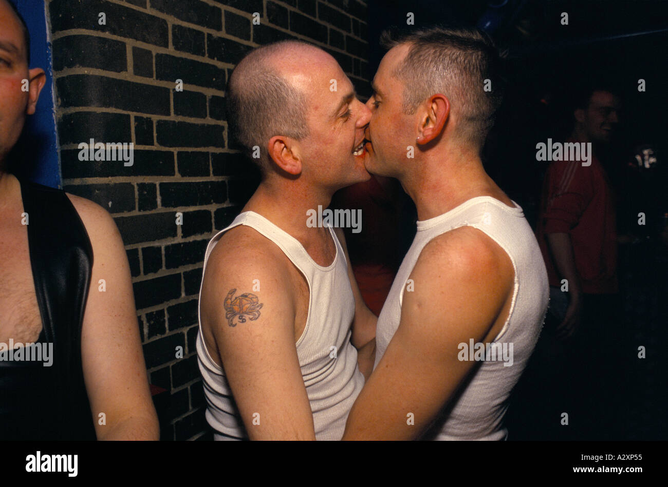 GAY PAAR KÜSSEN AUF DEN LIPPEN AM UMSPANNWERK SÜD, CLUB IN BRIXTON, LONDON, ENGLAND Stockfoto