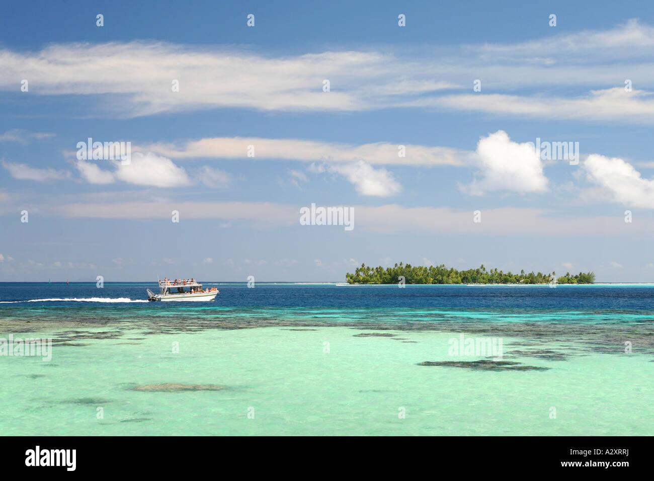 Speed-Boot in Bora Bora Lagune mit Whispy Wolken Stockfoto