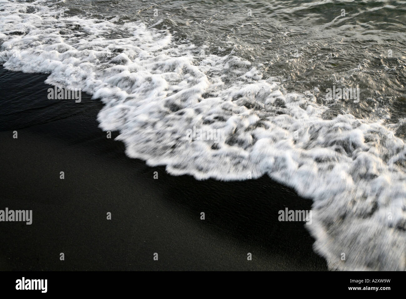 Weiße Welle auf schwarzen Sand auf Lake Taupo Neuseeland Nordinsel Stockfoto