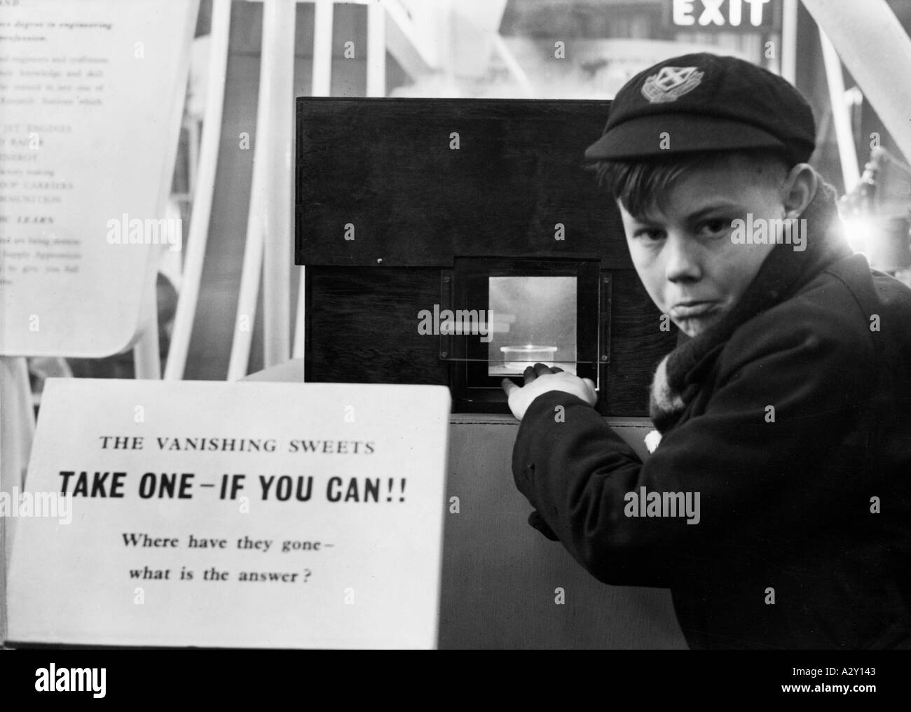 Das britische Versorgungsministerium zeigte seinen Sinn für Humor auf der Schuljungen-eigenen Ausstellung im Januar 1951 Scherz eine optische Illusion hat den Besuchern den Appetit auf Süßigkeiten aufgewertet und sie eingeladen, einen zu nehmen, wenn Sie können, aber wie Staffan ging durch die Eröffnung das Bild verschwand das britische Versorgungsministerium erlaubte sich bei einer Ausstellung im Januar 1951 einen Scherz ein optischer Trick macht dem Betrachter Appetit auf Suesses und laedt ihn ein danach zu greifen Sobald aber die Hand durch die Oeffnung schluepft verschwindet das Bild Curious Moments S 429 Stockfoto
