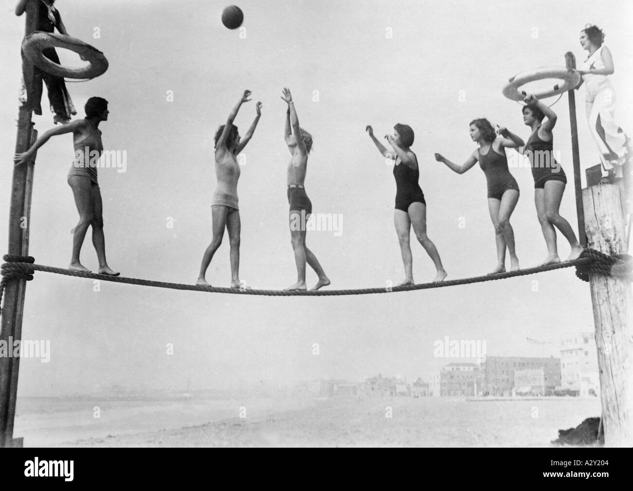 Erst in den 1920er und 1930er Jahren konnten sich die breiten Massen auf dem Gelände Vergnügen am Meer, aber als sie anfingen, haben sich die Urlauber in ihren Versuchen übertroffen, einen Weg zu finden, um das Monotone zu überwinden zwischen den Tauchgängen spielen diese Badeschönheiten am kalifornischen Venice Beach Drahtseilbasketball erste in den 1920er und 1930er Jahre beginnt die Freizeit am Meer ein Vergnuegen für die breite Masse zu werden Gleichzeitig uebertrumpfen sich die Badegaeste gegenseitig in ihren Bemühungen die Langeweile zwischen den Badegaengen zu ueberbrücken Diese Badenixen am Stockfoto