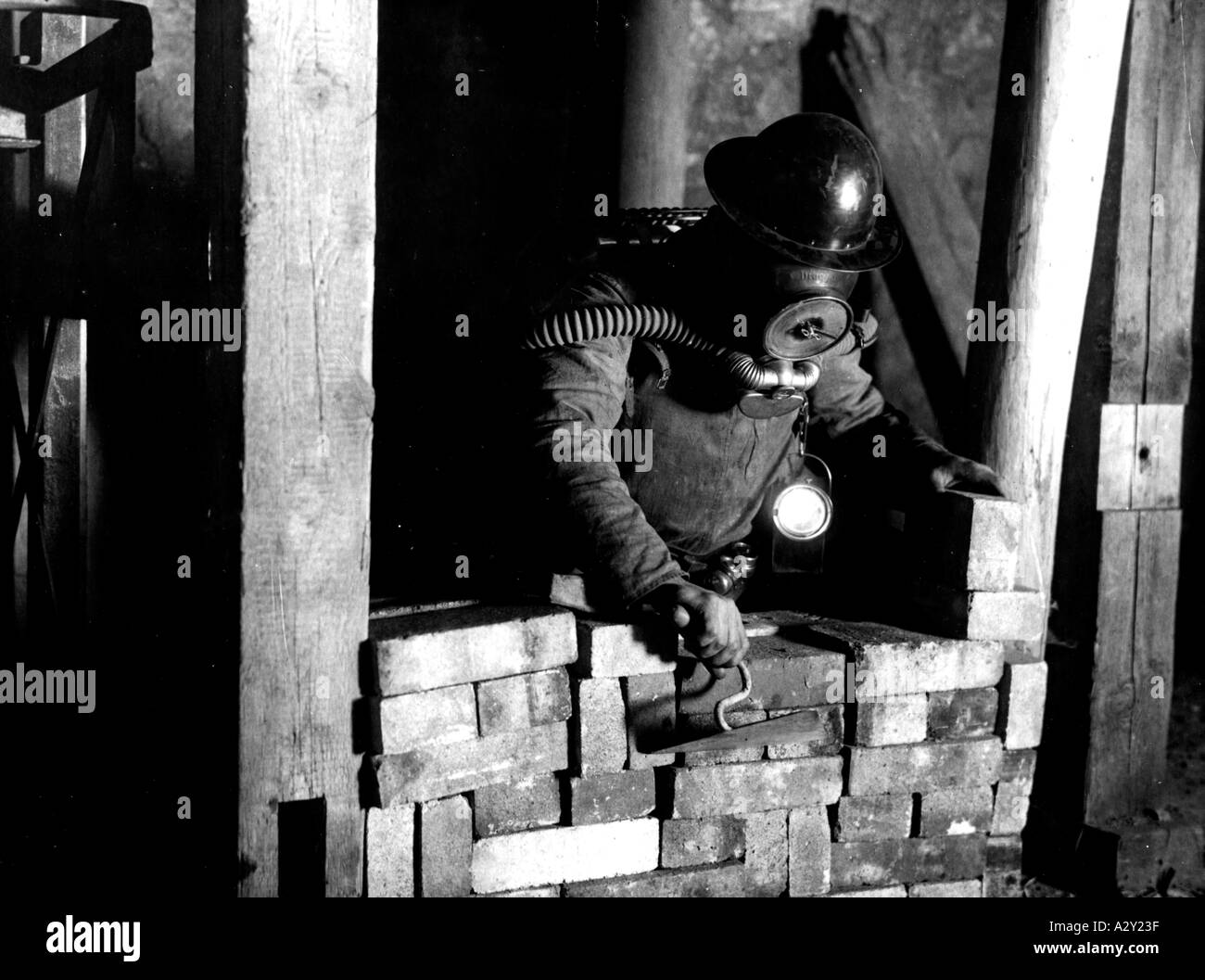 Ein Bericht der Bergakademie Freiberg in Sachsen aus den 1930er Jahren enthielt dieses Bild eines Studenten, der im Falle eines Gasflugs eine Galerie einmauert, um einen Feuerbruch zu schaffen. Aus einer Reportage ueber die deutsche Bergakademie Freiberg stammt dieses Bild aus den 1930er Jahren ein Student uebt für den Notfall das Mauern eines Branddammes im vergasten Schacht Curious Moments S 632 Stockfoto