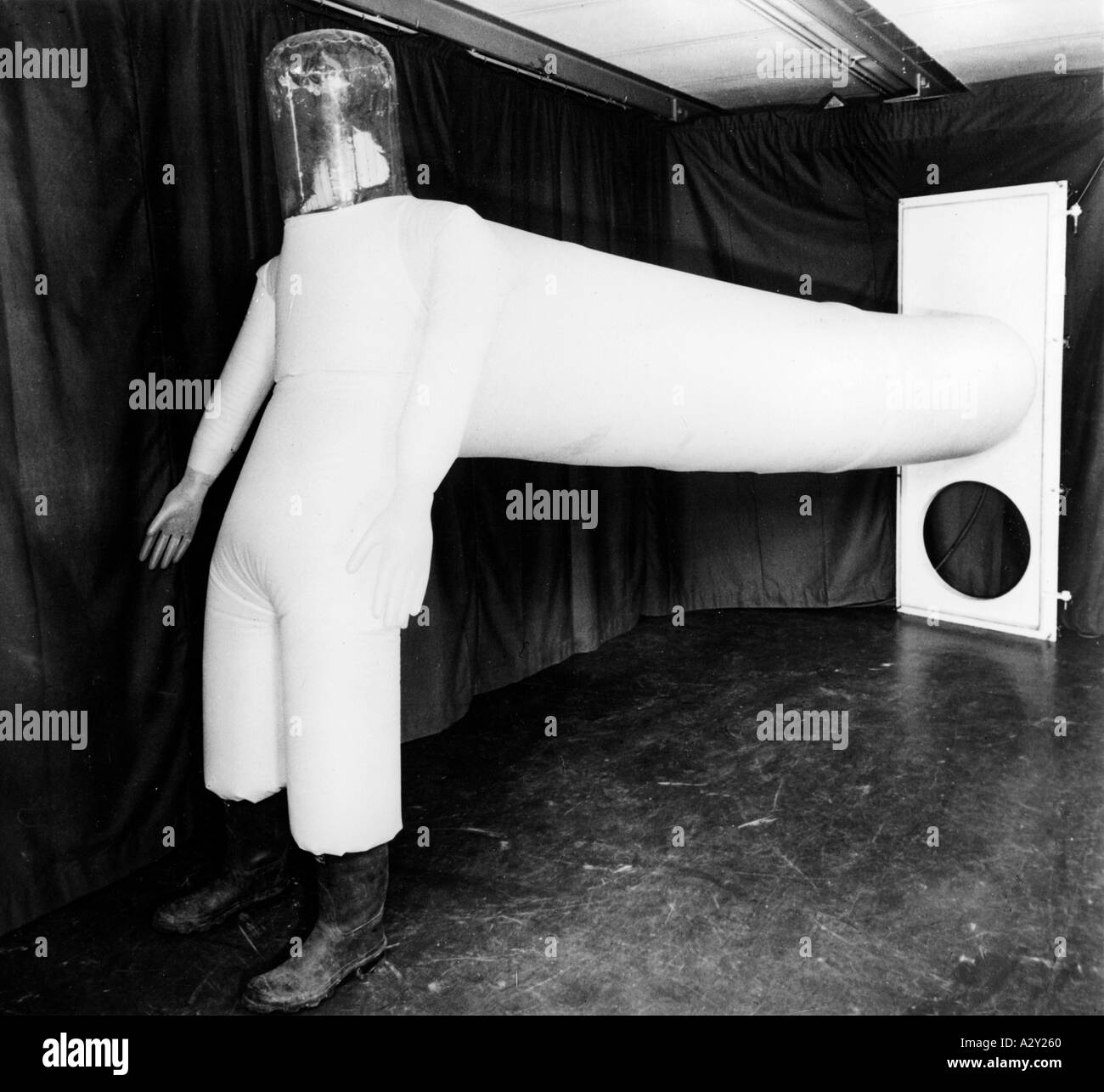 Die zivile Nutzung der Kernenergie bedeutete eine breitere Palette an Schutzkleidung und Sicherheitsmaßnahmen für die in kontaminierten Gebieten arbeitenden Personen dieser PVC-Anzug aus dem Jahr 1958 wird durch die Tür mit der zivilen Nutzung der Atomspaltung erweitert sich das Angebot an Sicherheitskleidung und technik für die Arbeit in kontaminierten Raeumen dieser PVC Anzug von 1958 wird durch die Tuer bestiegen Curious Moments S 657 betreten Stockfoto