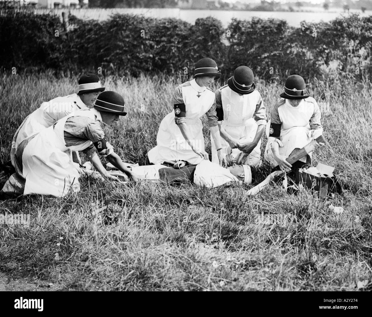 Engländerinnen, die während des Ersten Weltkriegs als medizinisches Hilfspersonal gedient hatten, sind abgebildet, die ihre wertvolle Freizeit aufgeben angesichts der steigenden Zahl von Verkehrsunfällen fungierten sie als freiwillige erste-Hilfe-Helfer für Verkehrsopfer wie etwa wie hier auf der Straße zwischen Sturry und Sarre in Kent ehemalige englische Sanitaetshelferinnen die im Ersten Weltkrieg dienten opfern Ihre kostbare Freizeit in Anbetracht der steigenden Zahl von Verkehrsunfaellen versorgt sie die Opfer ehernamtlich wie hier auf der Straße zwischen Sturry und Sarre in der Grafschaft Kent Kuriositäten S 670 Stockfoto
