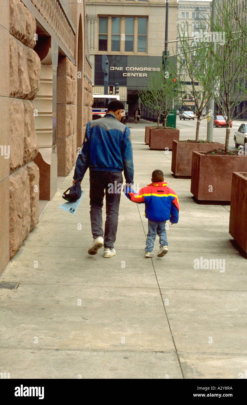 Afroamerikanischen Vater und Sohn im Alter von 28 und 4 Hand in Hand gehen Innenstadt. Chicago Illinois USA Stockfoto