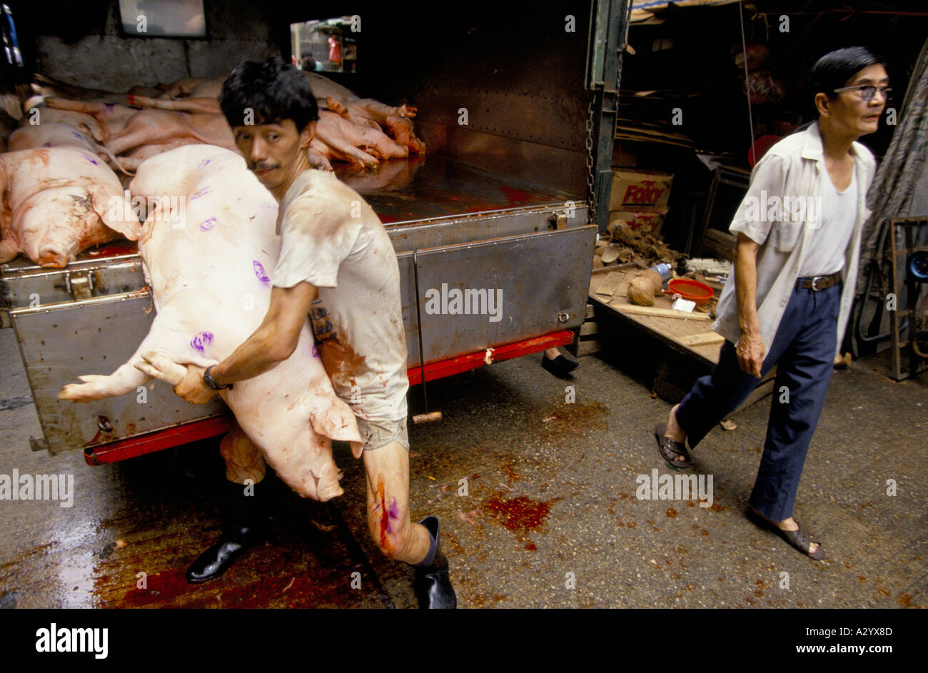 Mann entladen Schweinehälften aus der Rückseite des ein LKW Mong Kok in Hongkong Stockfoto