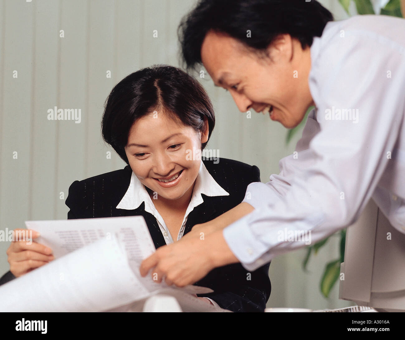 eine junge Geschäftsfrau und Mann sprechen in einem Büro Stockfoto