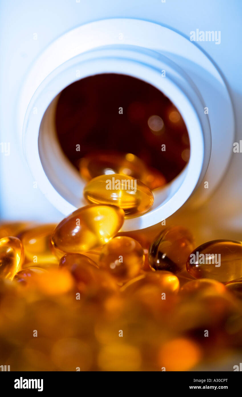 Glänzende gelbe Pillen zu verschütten aus Flasche Stockfoto