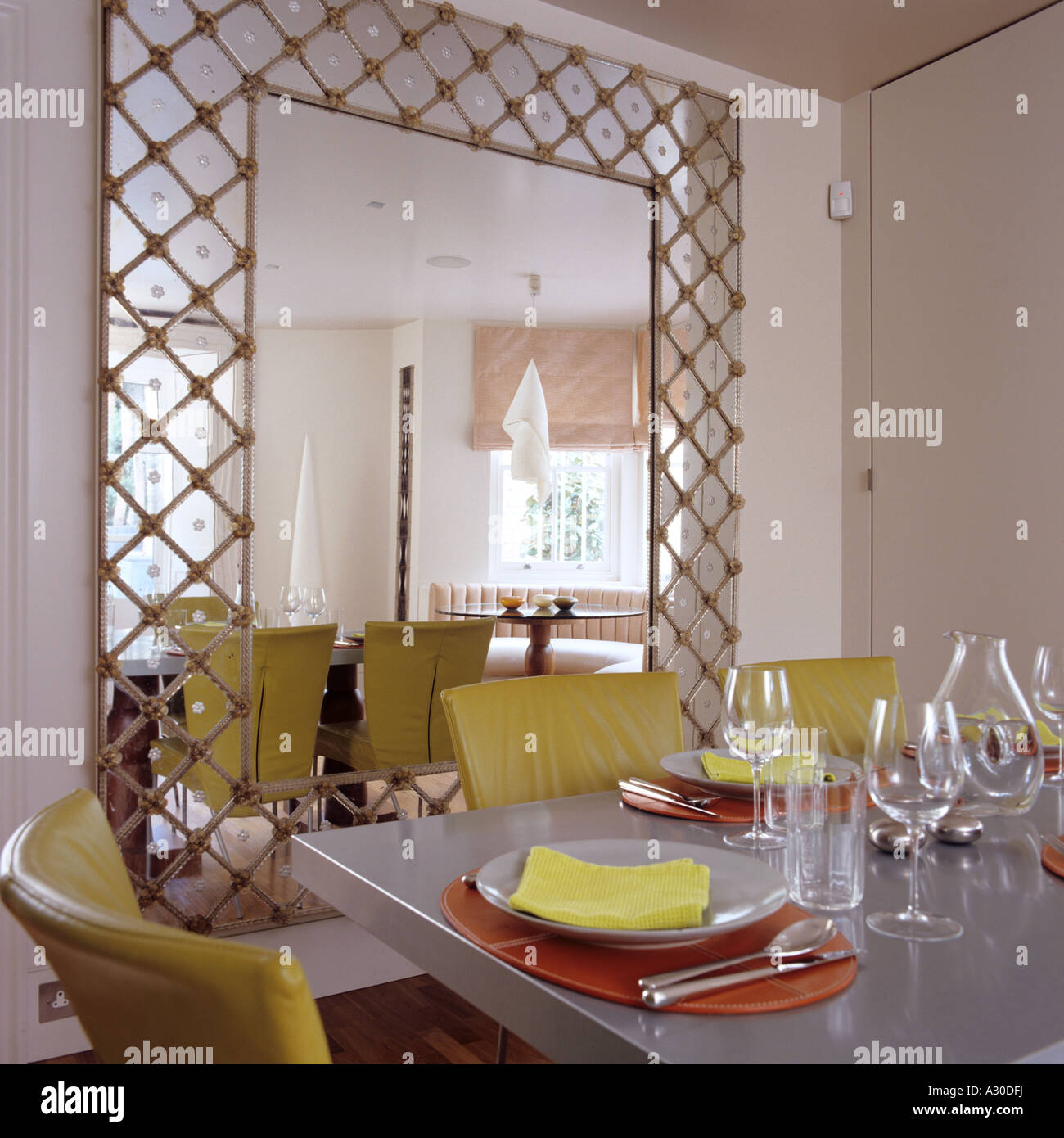 Übergroßer Spiegel mit Laubsägearbeiten im Esszimmer mit Tisch und  Lederstühlen gelb Stockfotografie - Alamy