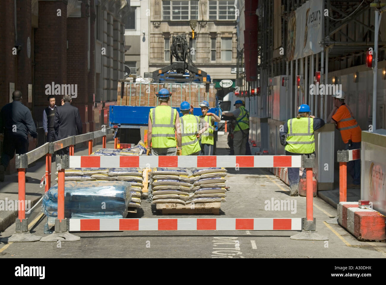 Straßensperren und Bauarbeiter in Schutzhüten und hohen Vis Weste geschlossen enge Straße Job Entladen Baustellenmaterial City of London England Großbritannien Stockfoto