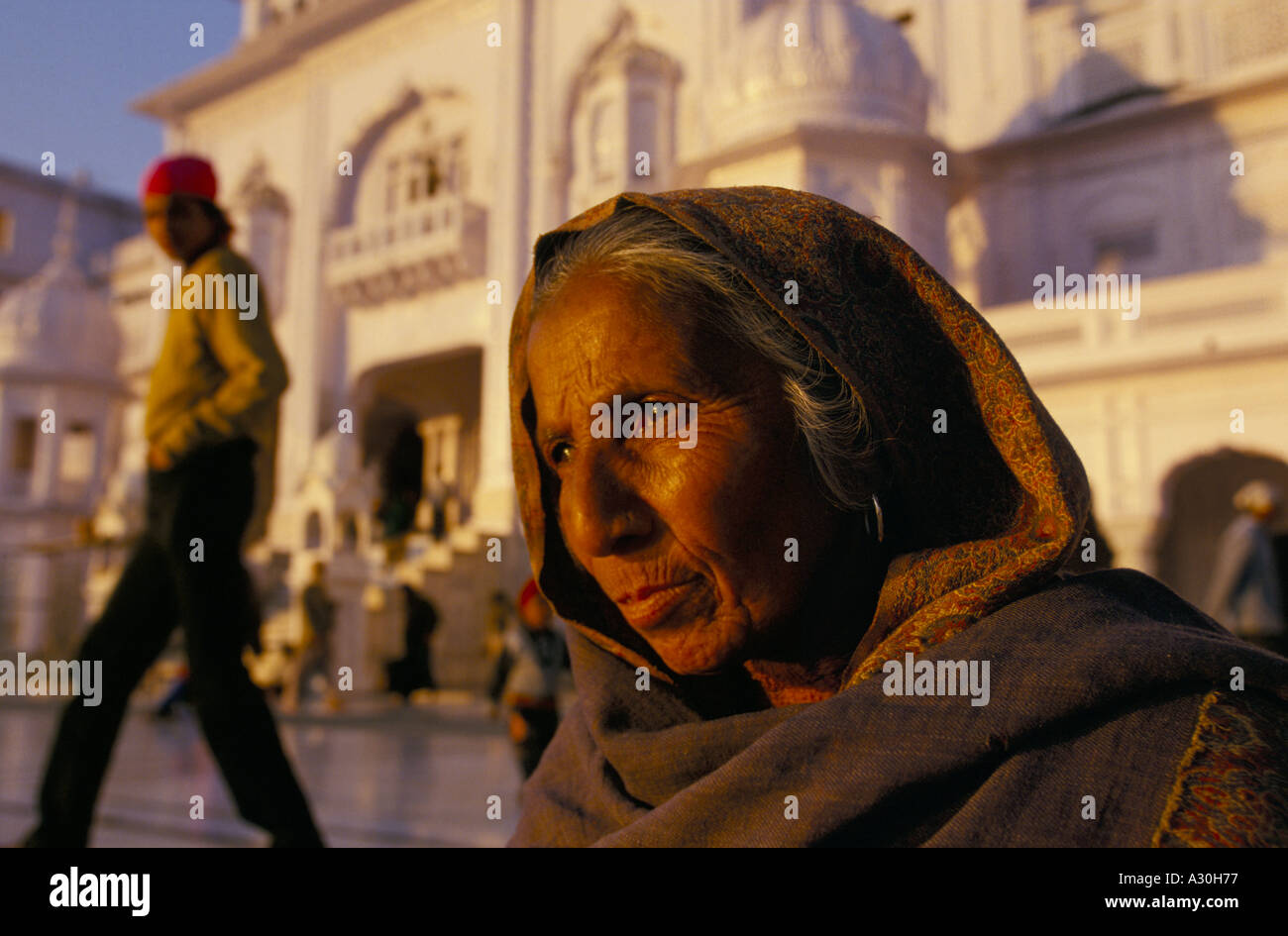 Eine alte Frau sitzt im Goldenen Tempel Amritsar Punjab Indiens Stockfoto