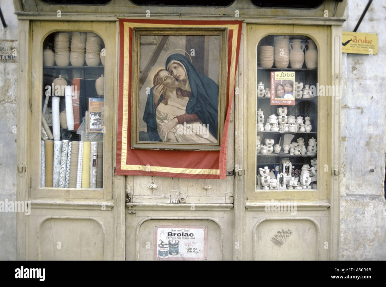 religiöse Gemälde der Madonna hält den toten Leib Christi hängen vor Geschäft mit Keramik Töpfe Vasen Stockfoto