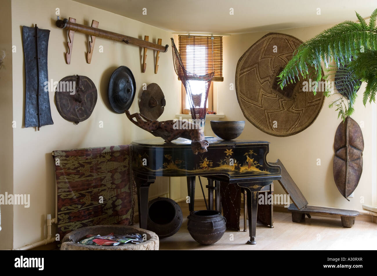 Ecke eines Raumes mit Baby Grand Piano und afrikanische Kunstobjekte Stockfoto