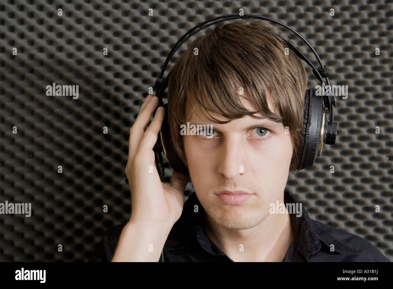 Junger Mann tragen Kopfhörer im Aufnahmeraum Stockfoto
