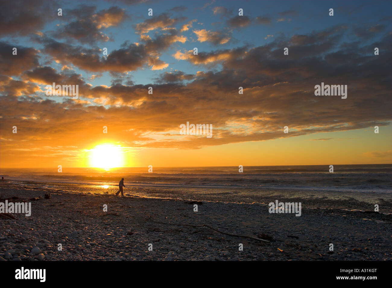 Einsame Figur wie die Sonne Strand Kämmen setzt auf die Tasmanische See auf der Südinsel Neuseelands. Stockfoto