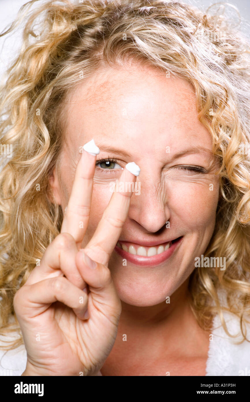 Frau, Lächeln und Feuchtigkeitscreme auftragen Stockfoto