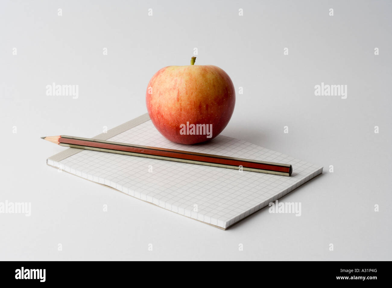 Apple und Bleistift auf Notizblock Stockfoto