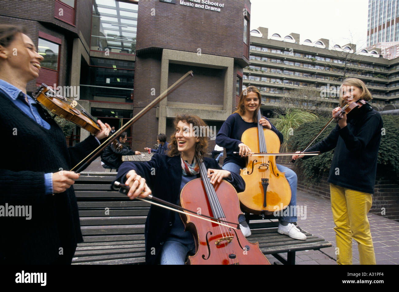 lachend weibliche Streichquartett an der Guildhall School of Music spielen im Freien im Barbican centre London Stockfoto
