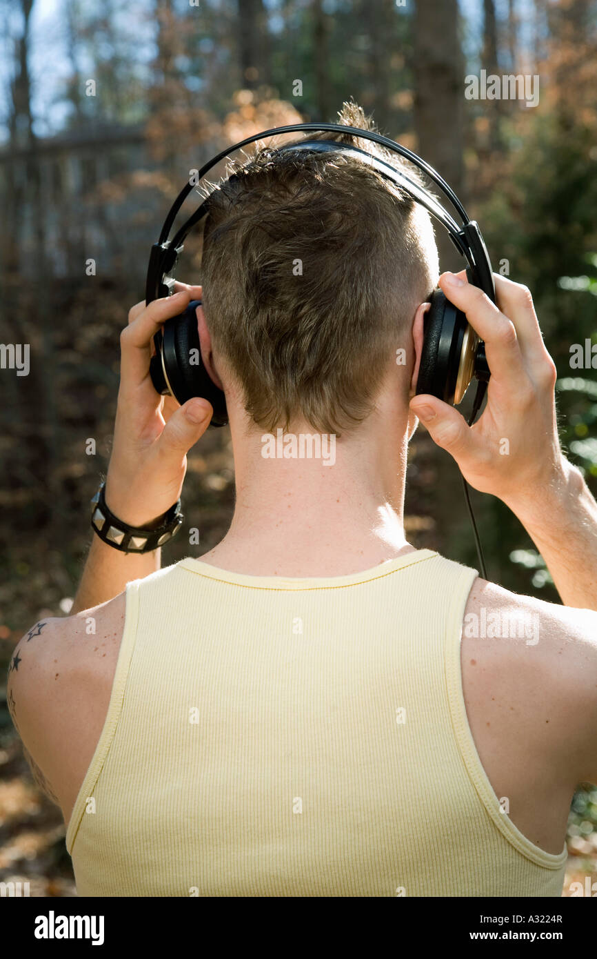 Mann im Wald stehen und tragen von Kopfhörern Stockfoto
