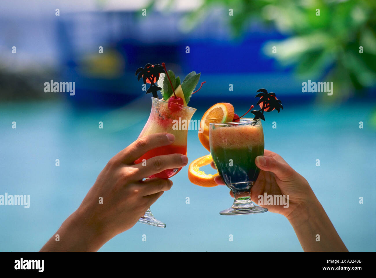 Zwei Menschen, die mit bunten tropischen Drinks Toasten Stockfoto