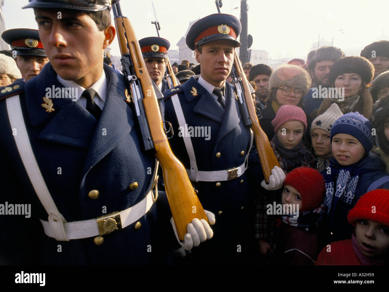 Rumänien nach der Revolution Kinder unter den Massen Versammelten sich rund vier Soldaten paradieren in einheitlicher Kleidung mit Gewehre geschultert während der Tag der Trauer gewidmet denen, die in der Revolution Bukarest 1990 starb Stockfoto