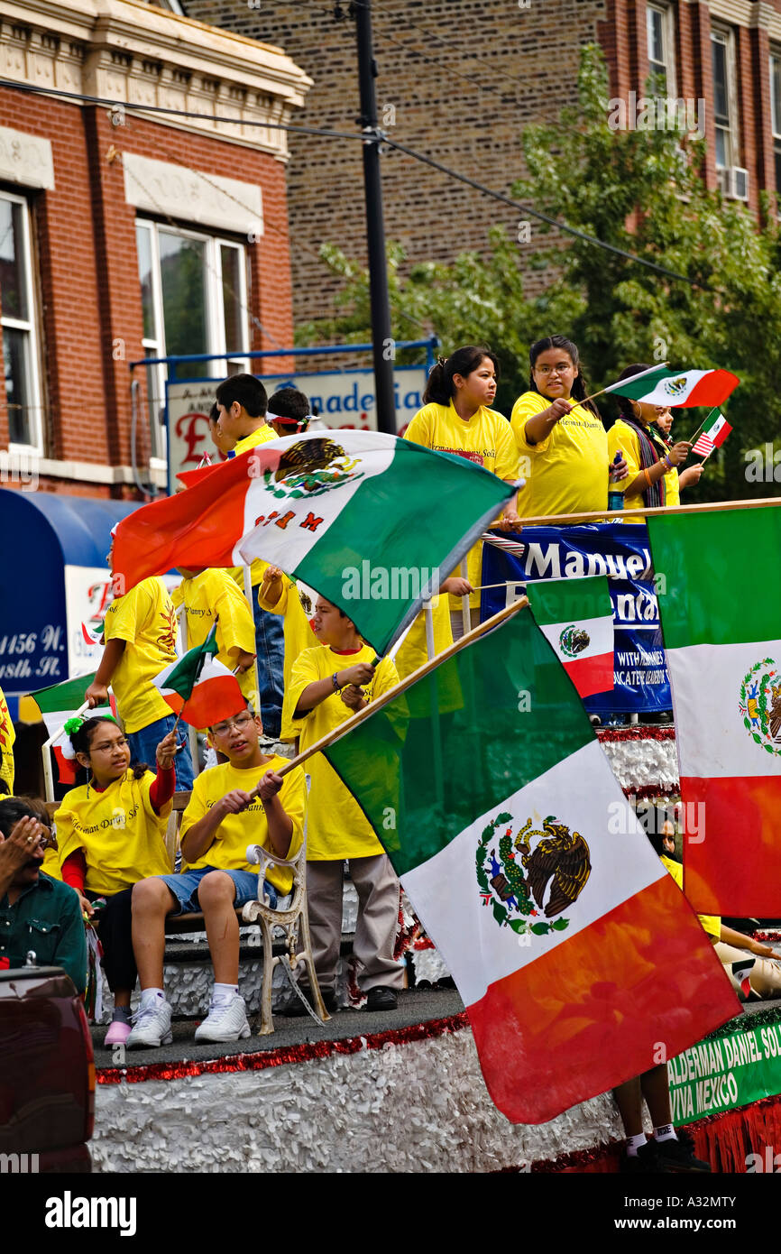 ILLINOIS-Chicago-Jungen und Mädchen Welle mexikanische Flaggen am Schwimmer im mexikanischen Unabhängigkeitstag Parade Pilsen Stockfoto